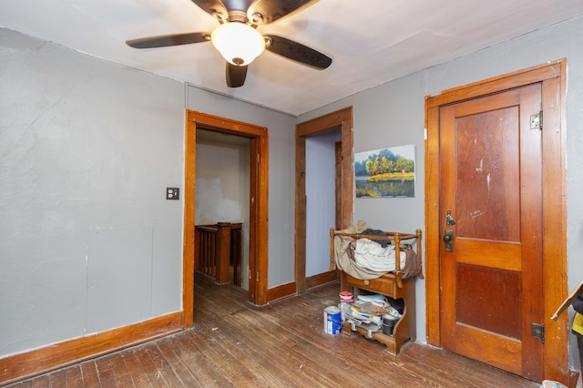 corridor featuring wood-type flooring and baseboards