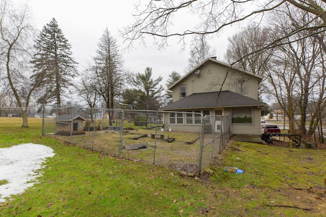 rear view of property with a yard and fence