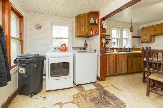 clothes washing area with laundry area, wooden ceiling, independent washer and dryer, light floors, and a sink