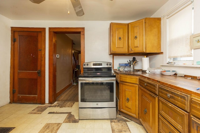 kitchen featuring brown cabinets, dark countertops, visible vents, electric range, and ceiling fan