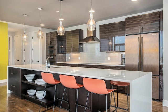 kitchen with tasteful backsplash, a spacious island, refrigerator, stainless steel double oven, and a sink