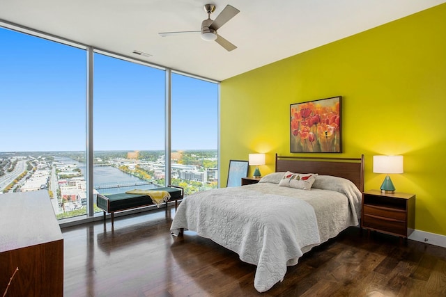 bedroom featuring a ceiling fan, baseboards, visible vents, floor to ceiling windows, and dark wood-style floors