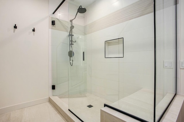 full bathroom with a stall shower and baseboards