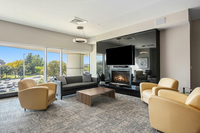 living room featuring a glass covered fireplace and visible vents