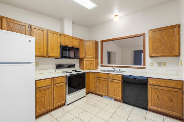 kitchen with black appliances, a sink, light countertops, and brown cabinets