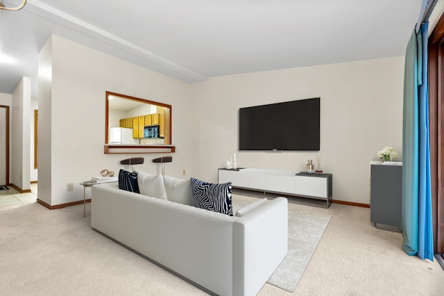 living room featuring baseboards and light colored carpet