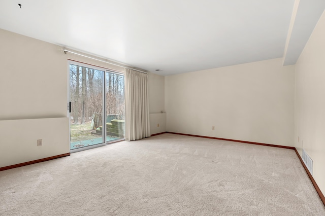 carpeted spare room with visible vents and baseboards