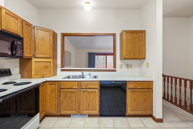 kitchen with a sink, black appliances, light tile patterned floors, and light countertops