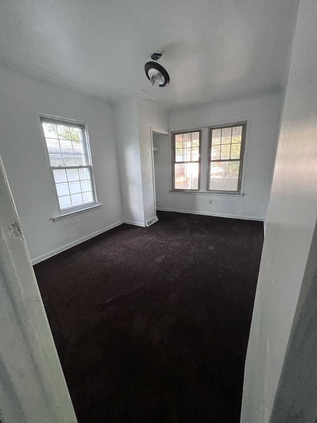 unfurnished room with baseboards