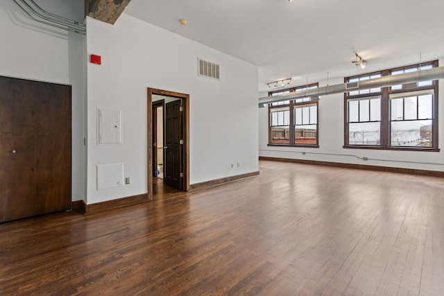 unfurnished room with track lighting, baseboards, visible vents, and hardwood / wood-style floors