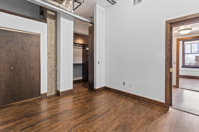 unfurnished bedroom with baseboards, visible vents, and wood finished floors