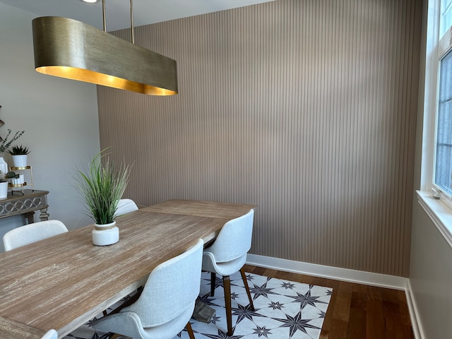 dining space with baseboards and wood finished floors