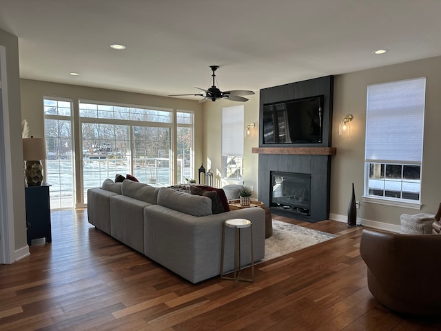 living area with recessed lighting, a fireplace, baseboards, and wood finished floors