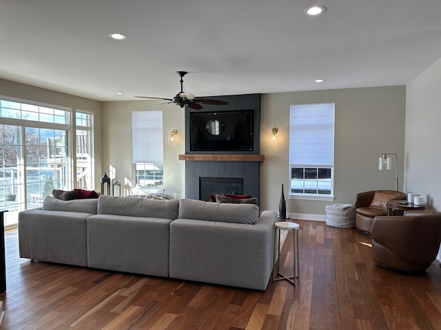 living area with a fireplace, recessed lighting, a ceiling fan, wood finished floors, and baseboards