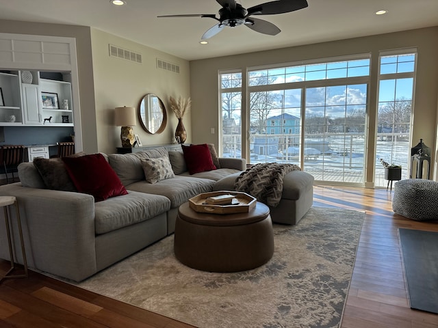 living room with visible vents, plenty of natural light, and wood finished floors