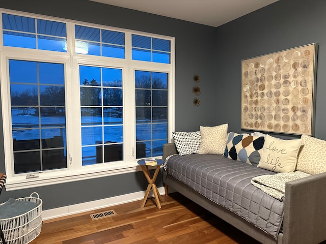 living room with wood finished floors, visible vents, and baseboards