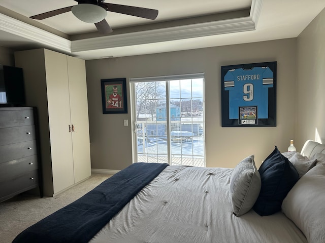 bedroom with access to outside, a tray ceiling, ceiling fan, and light colored carpet