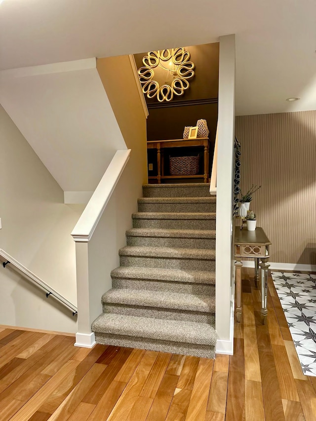 staircase with baseboards and wood finished floors