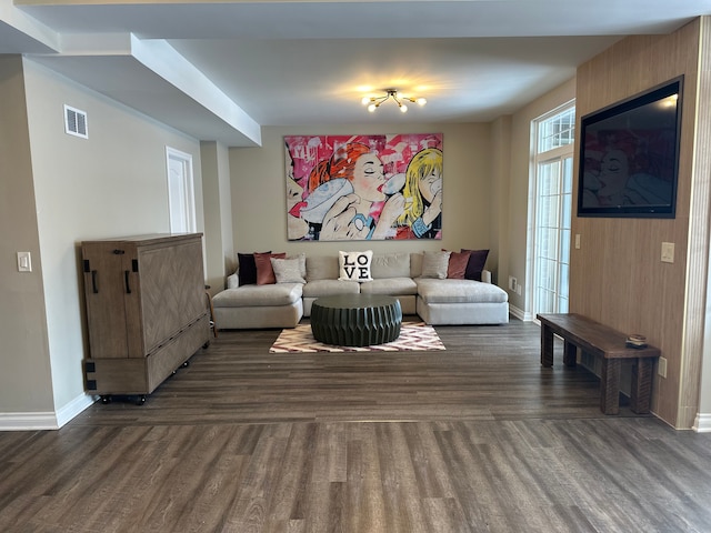 living room featuring dark wood-type flooring, visible vents, and baseboards