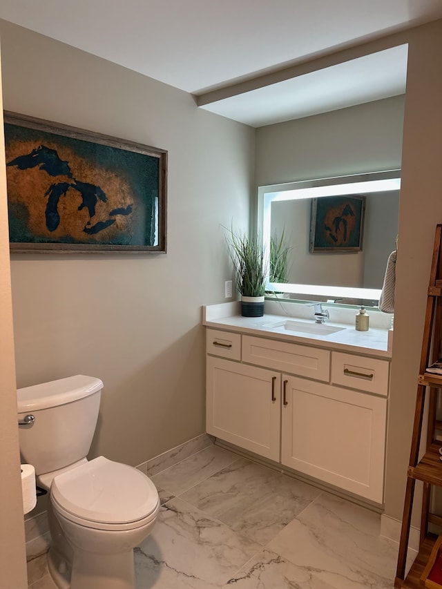 half bath with marble finish floor, vanity, toilet, and baseboards