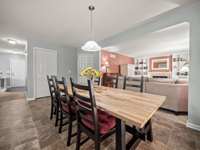 dining room featuring stone finish floor, visible vents, and baseboards