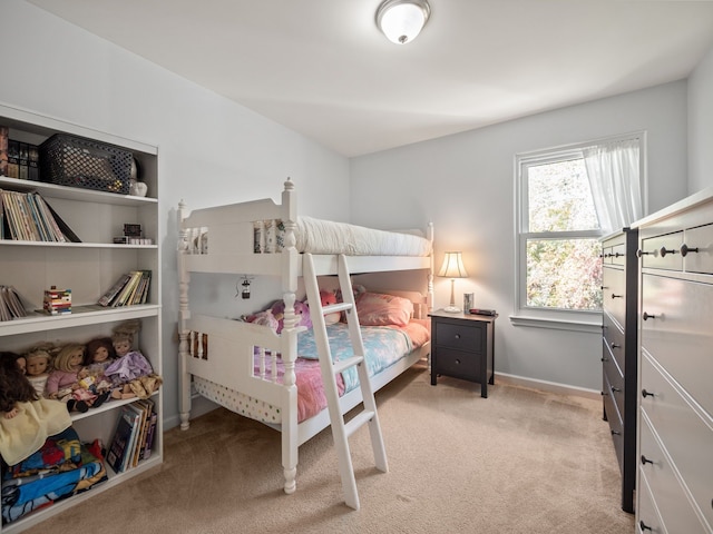 bedroom with baseboards and light colored carpet