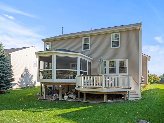 rear view of house with a deck, a yard, and a sunroom