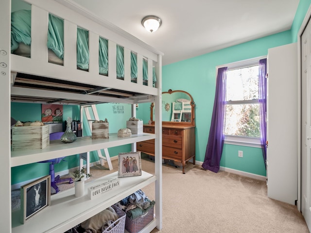 bedroom with light carpet and baseboards