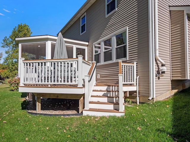 rear view of house with a deck and a lawn