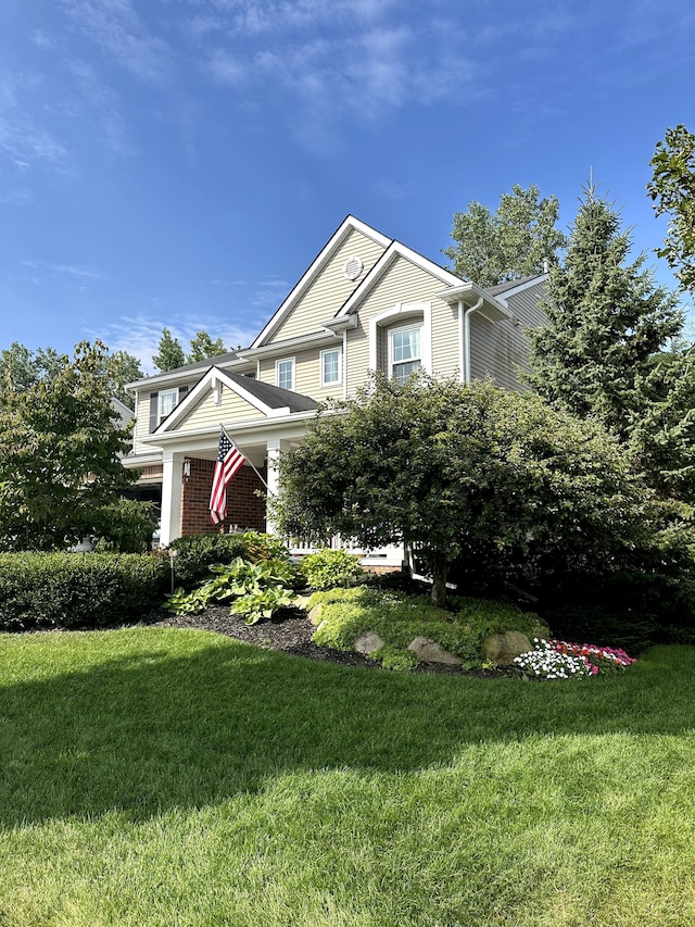 view of front of property featuring brick siding and a front lawn