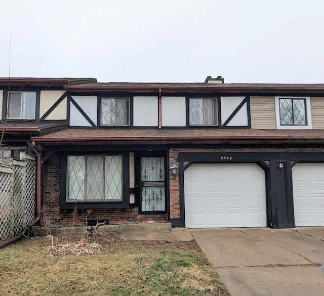 view of front of home with driveway, brick siding, and an attached garage