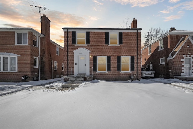 view of front of house with brick siding and a chimney