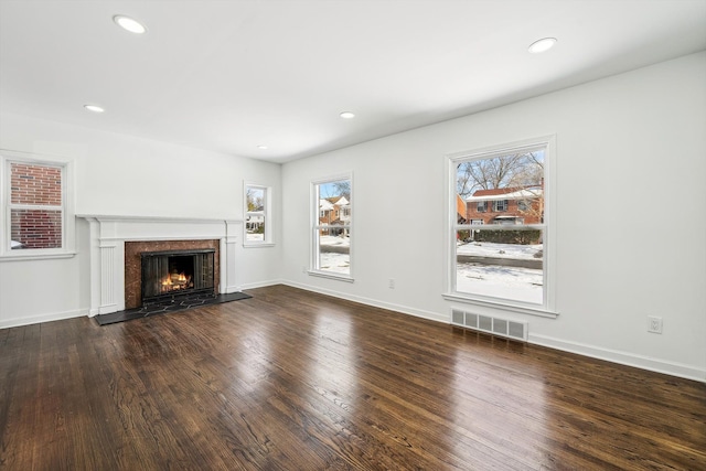 unfurnished living room featuring recessed lighting, a fireplace, wood finished floors, visible vents, and baseboards