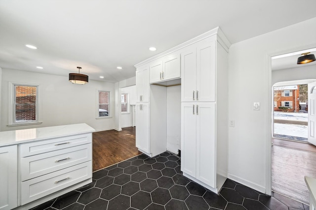 kitchen with recessed lighting, white cabinetry, dark tile patterned floors, and light stone countertops