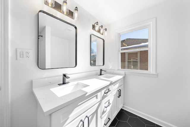 full bathroom with tile patterned floors, a sink, baseboards, and double vanity