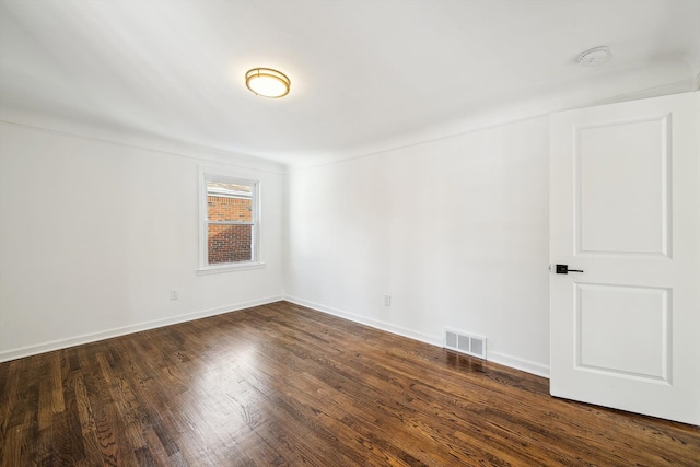 unfurnished room featuring dark wood-style floors, baseboards, and visible vents