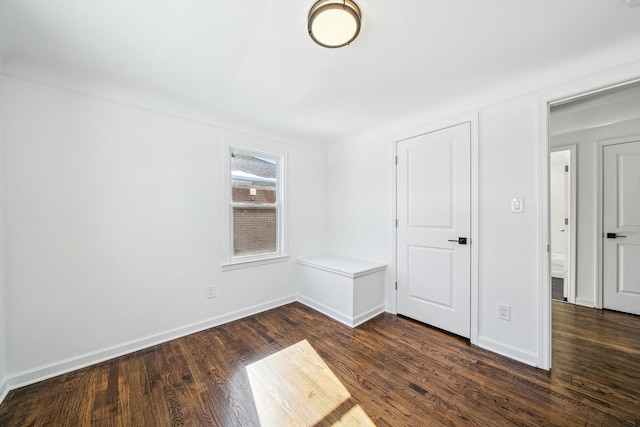 unfurnished bedroom featuring dark wood-style floors and baseboards