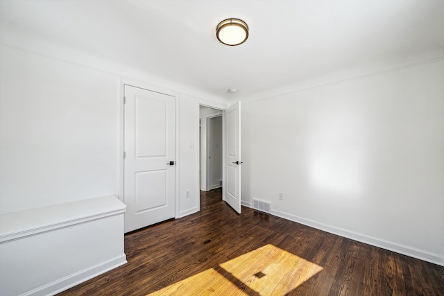 unfurnished bedroom featuring wood finished floors, visible vents, and baseboards