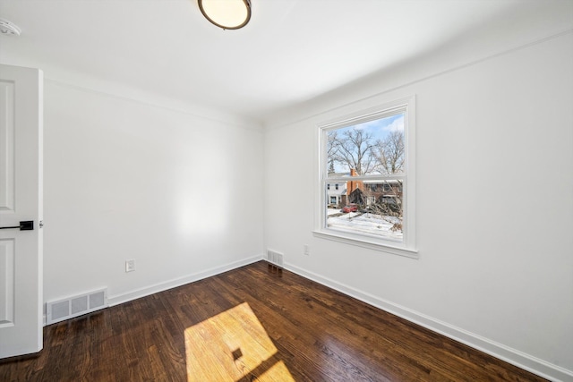 empty room with visible vents, baseboards, and wood finished floors