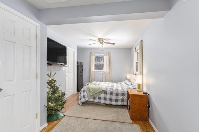 bedroom with baseboards, ceiling fan, and light wood finished floors