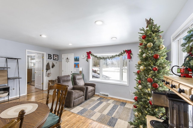 living area with visible vents, plenty of natural light, and wood finished floors