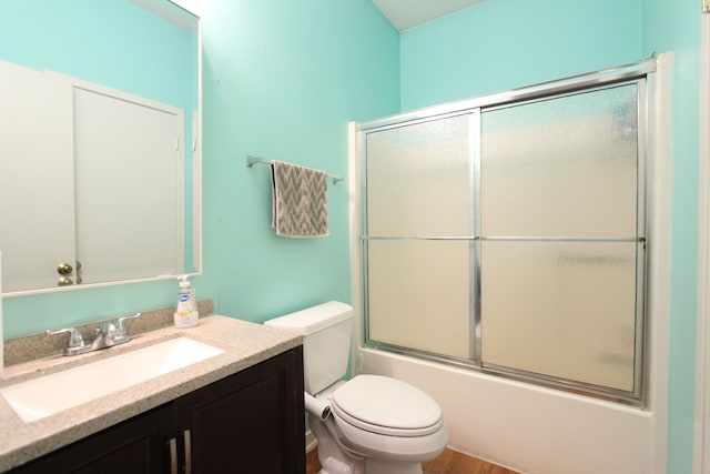 full bathroom featuring toilet, shower / bath combination with glass door, and vanity