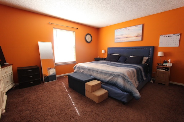 carpeted bedroom featuring baseboards and a textured ceiling