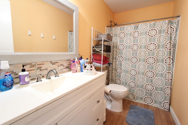 full bath with toilet, wood finished floors, vanity, decorative backsplash, and a shower with curtain