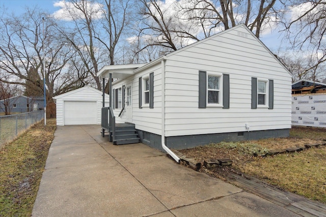 view of home's exterior featuring crawl space, fence, a garage, an outdoor structure, and driveway