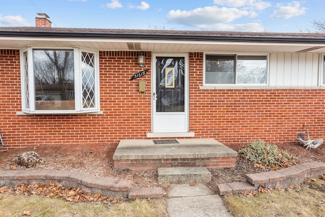 doorway to property with brick siding