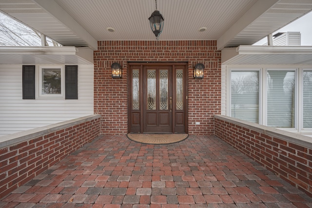 view of exterior entry featuring brick siding