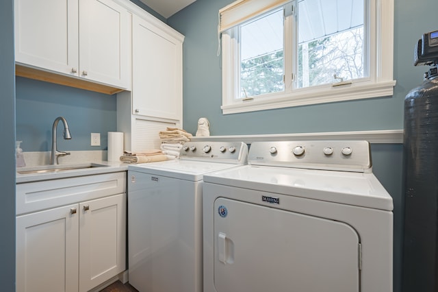 washroom with independent washer and dryer, cabinet space, and a sink