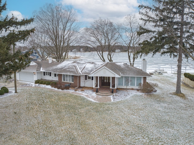 view of front of property with a garage, a chimney, and brick siding