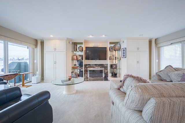 living room with a healthy amount of sunlight, carpet, a premium fireplace, and recessed lighting